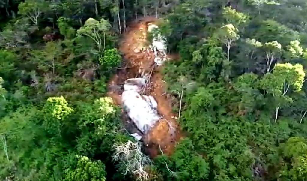 A pedra, que agora está sendo quebrada em pedaços menores, rolou na mata e só não atingiu casa por conta das árvores. Foto: Reprodução de vídeo/Oswald Cruz